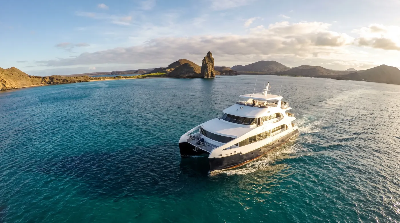 A luxury cruise yacht departing Bartolomé Island after a visit